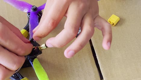 Hand-fixes-and-adjusts-heat-shrink-tubing-on-custom-built-FPV-quadcopter