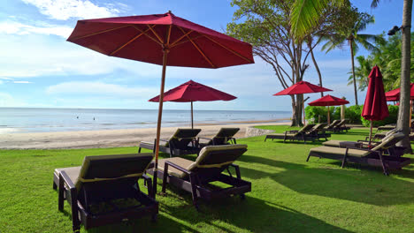 sombrilla roja y silla de playa con fondo de playa y cielo azul y luz solar