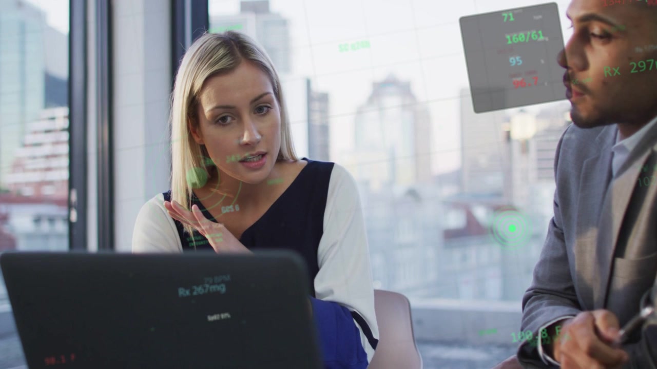 Woman showing finance charts on laptop gesturing, holo overlay responding between them, man nodding