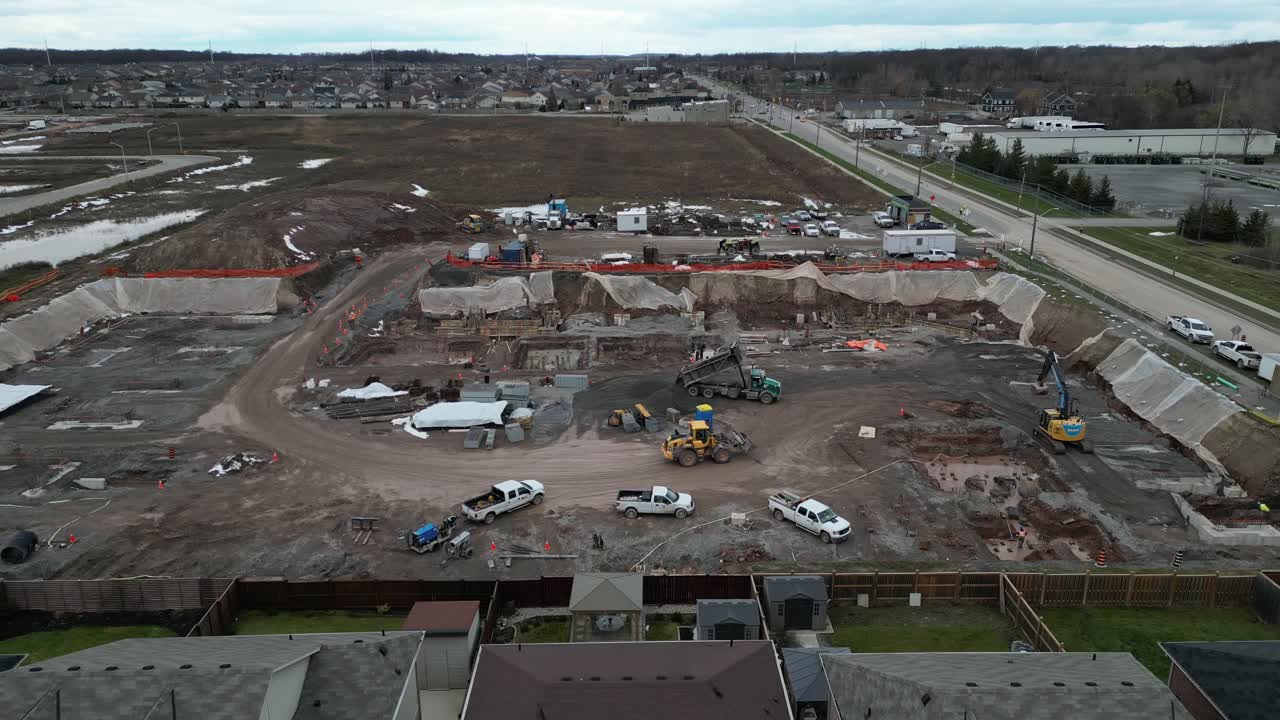 antena de construcción, excavadoras y camiones cavan cimientos para grandes edificios