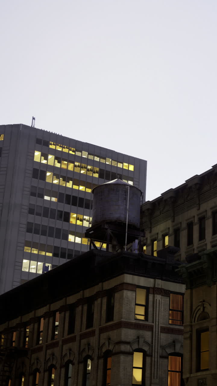 Edifici con torre dell'acqua di notte nello skyline di una città