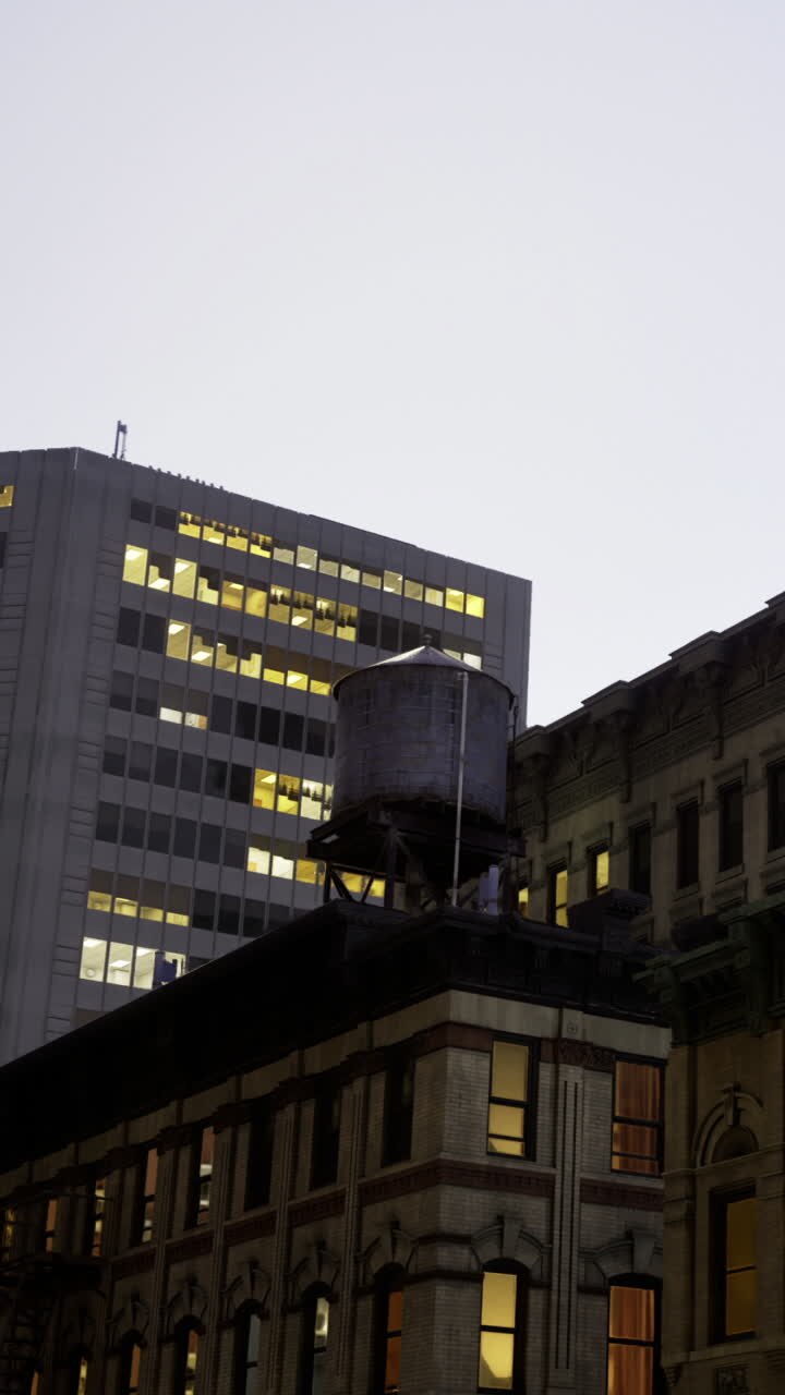 Edifici con torre dell'acqua di notte nello skyline di una città