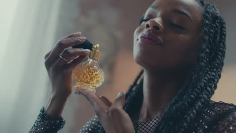 una modelo africana aplicando perfume vintage en su dormitorio.