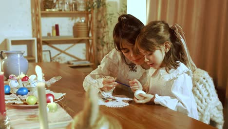 mother and daughter painting easter eggs