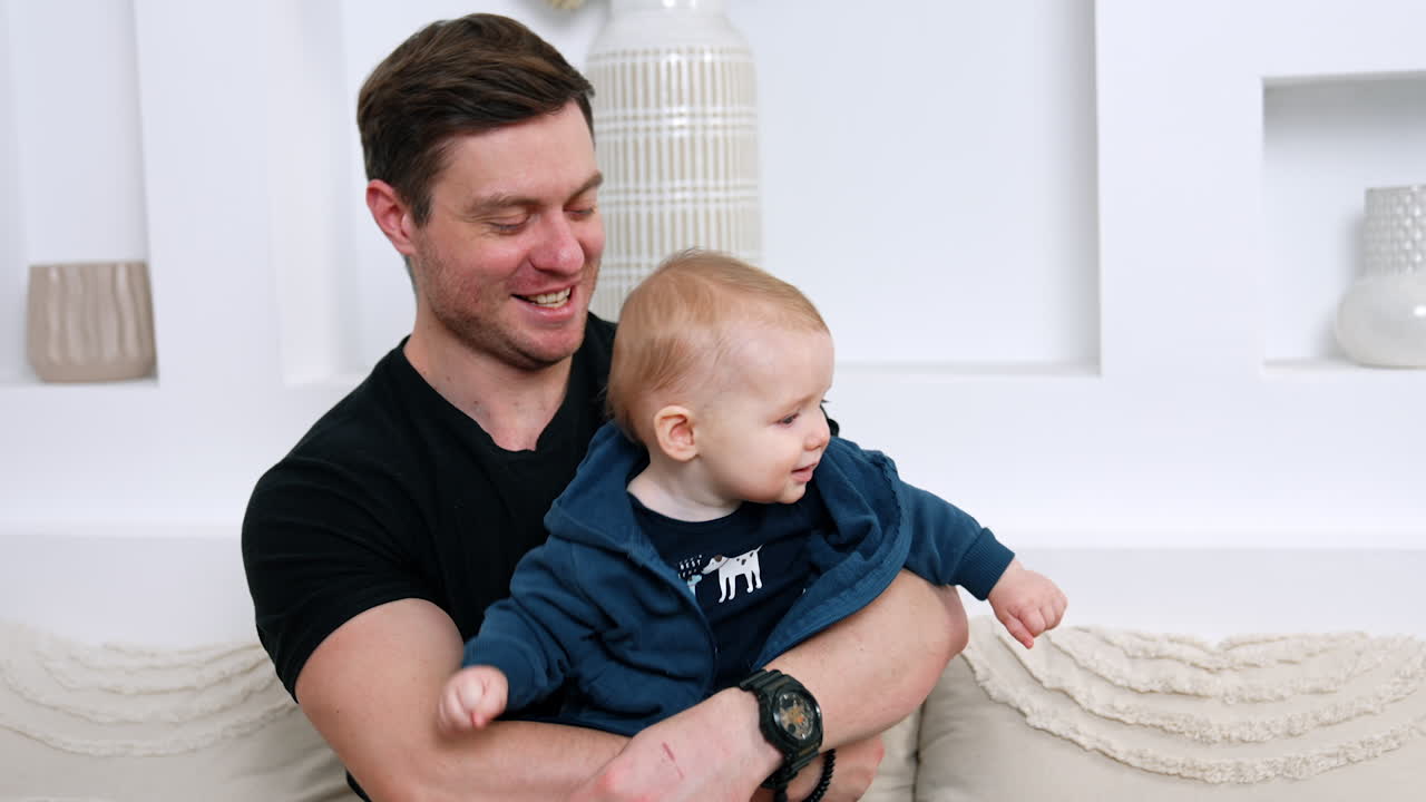 Loving father embracing and kissing his beloved baby. Dad playing and taking care of his child.