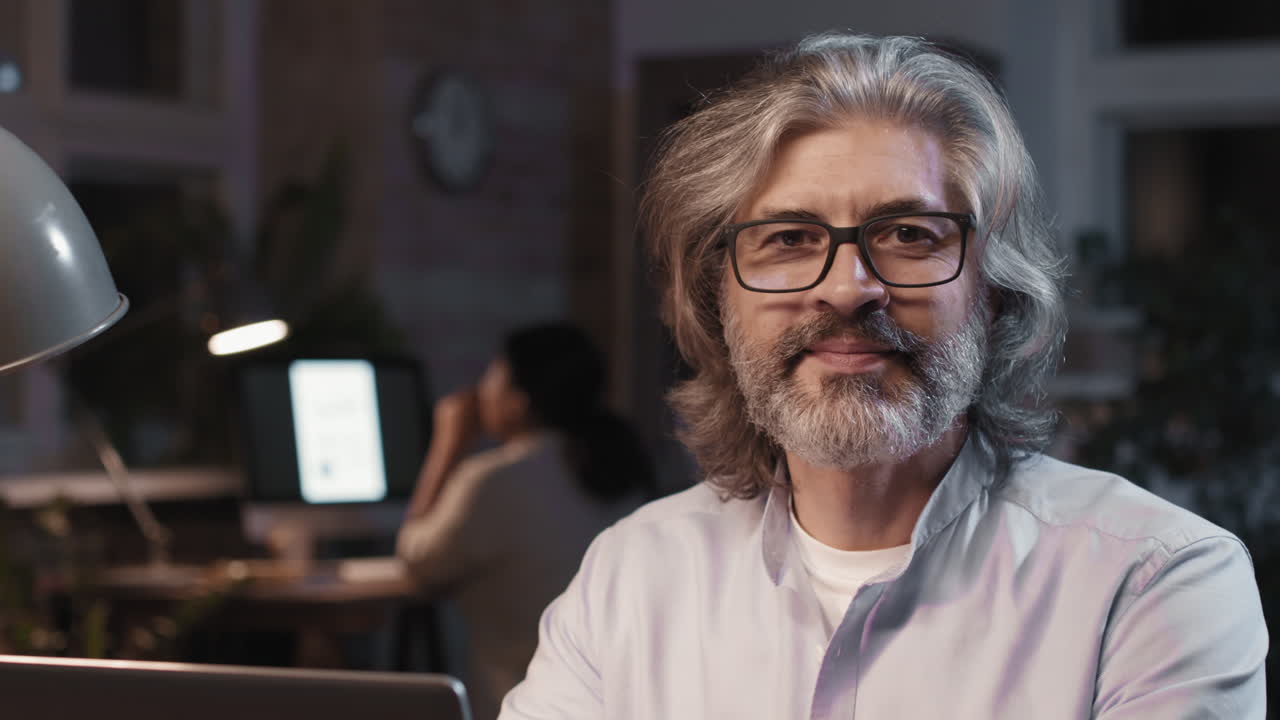 Focused Mature Man Working on Laptop at Night