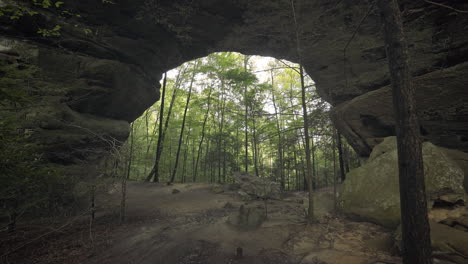 wide shot of huge natural stone arch bridge in green tennessee forest, 4k