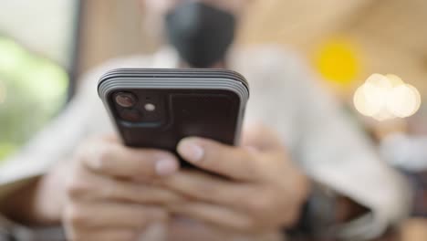 a young businessman wearing a surgical mask is taking a video conference with customers via a smart phone connected to the internet.