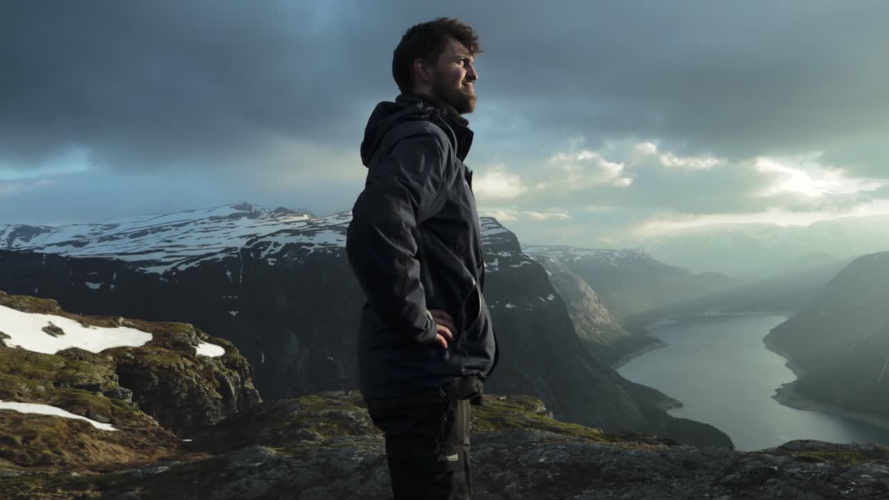 Happy man reached Trolltunga and overlook landscape, handheld view