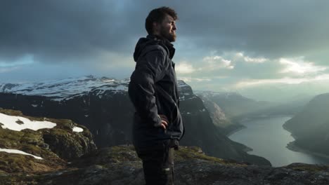 happy man reached trolltunga and overlook landscape, handheld view