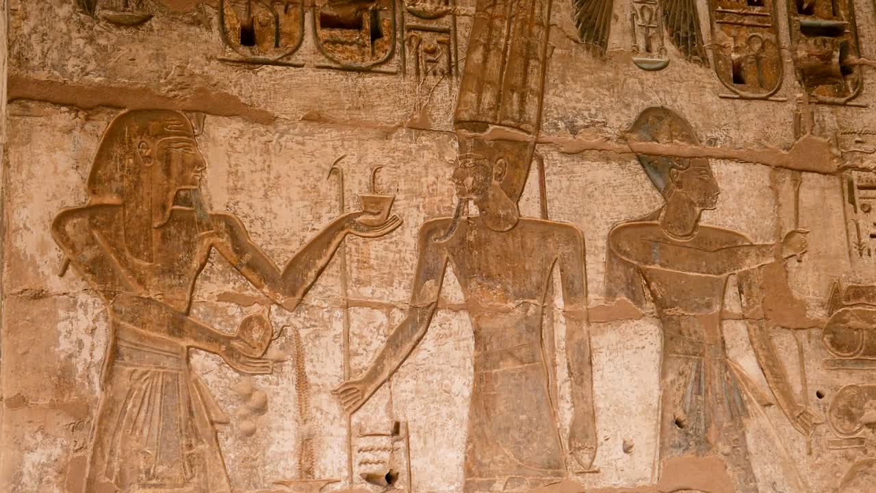 detalle de los antiguos jeroglíficos egipcios de personas y dios en una pared, templo habu, luxor, egipto