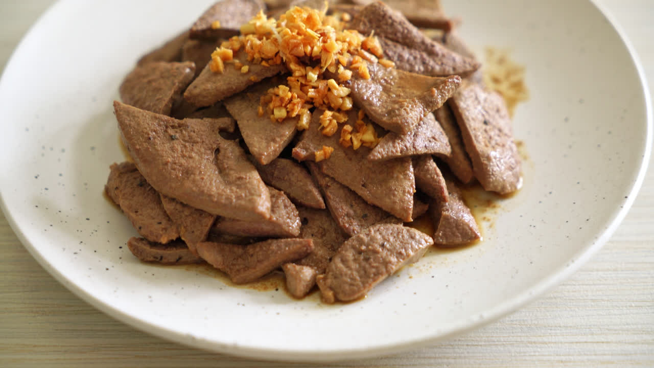 접시에 마늘을 곁들인 집에서 볶은 돼지 간