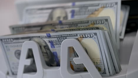 money counting machine. banknote counter are counting hundred dollar bills. close-up
