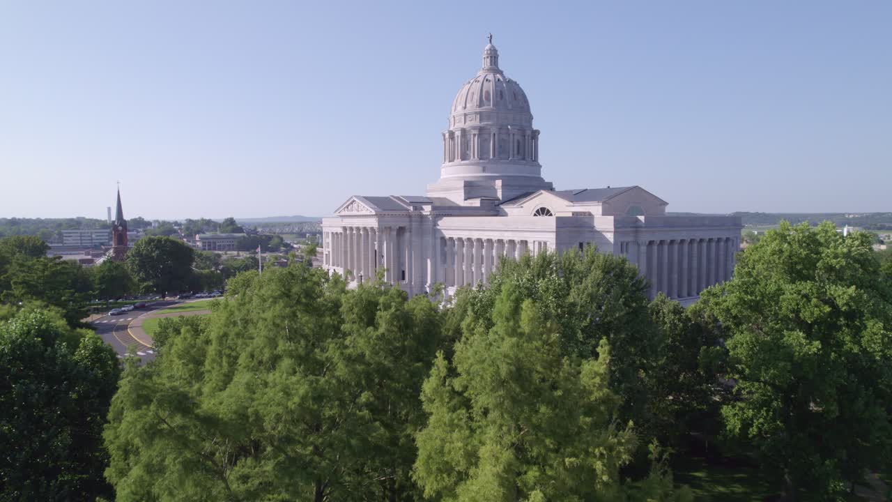 Soar through the skies over Jefferson City, showcasing the majestic Capitol building and its surroundings.