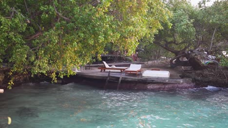 Relaxing-scene-of-lounge-chairs-on-a-dock,-surrounded-by-lush-forest-trees,-tranquil-and-peaceful-ambiance