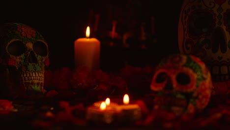 close up on still life of decorated skulls surrounded by candles and flower petals celebrating mexican holiday of dia de muertos or day of the dead 4