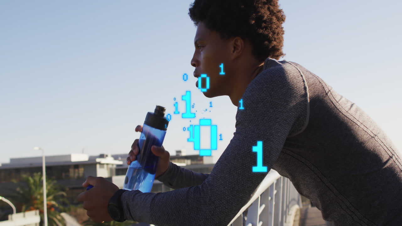 Animation of binary codes over african american male athlete drinking water on bridge against sky