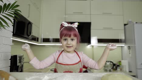 cooking pizza. little child playing with flour gets her hands dirty in kitchen
