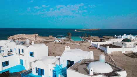 an aerial view of el biben island with a pool and hosting houses sits in the middle of the ocean with palm trees on it, surrounded by water creating a beautiful atmosphere