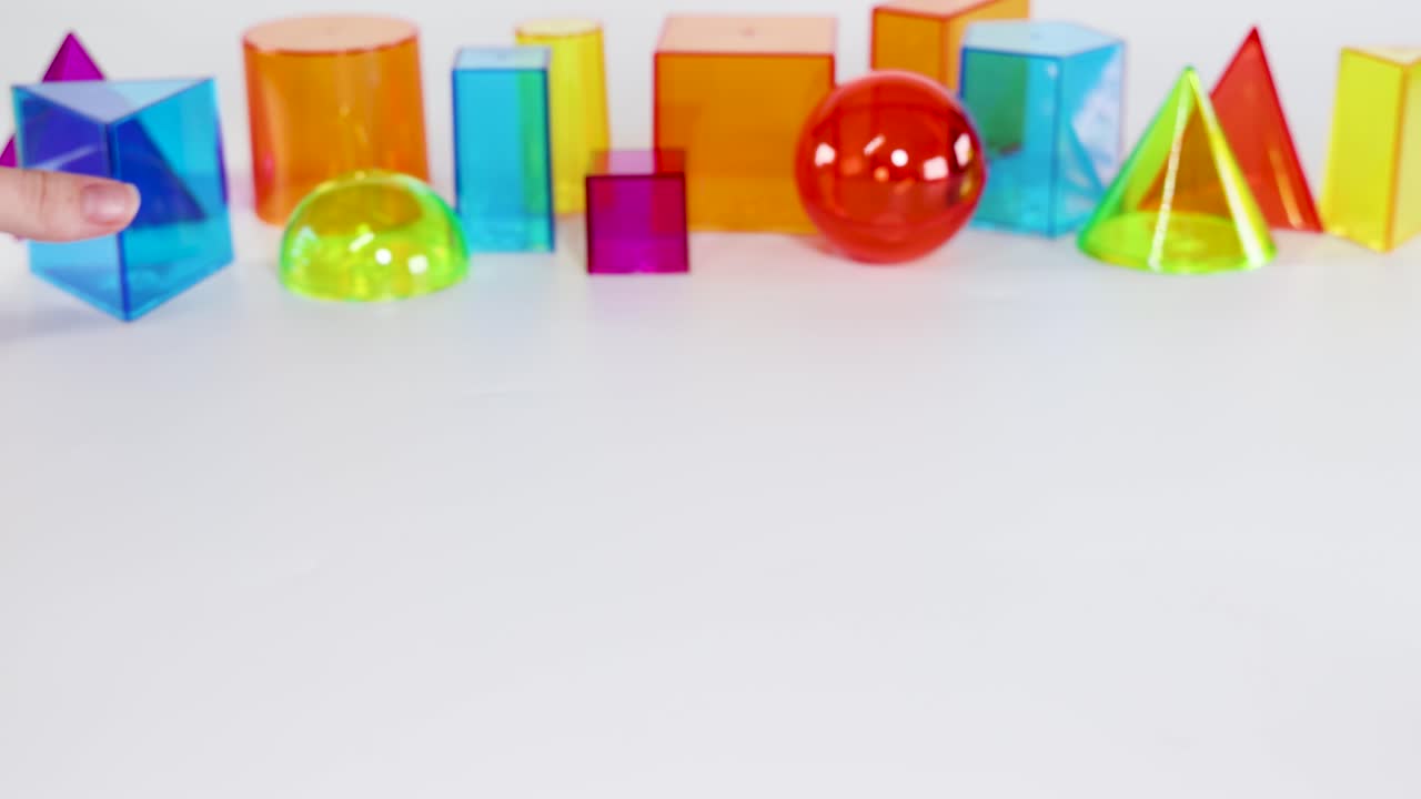 Vibrant geometric shapes move across a white background, showcasing dynamic interactions and colorful reflections