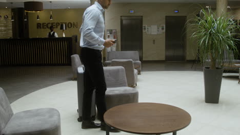 man sitting on a sofa in the hotel hallway