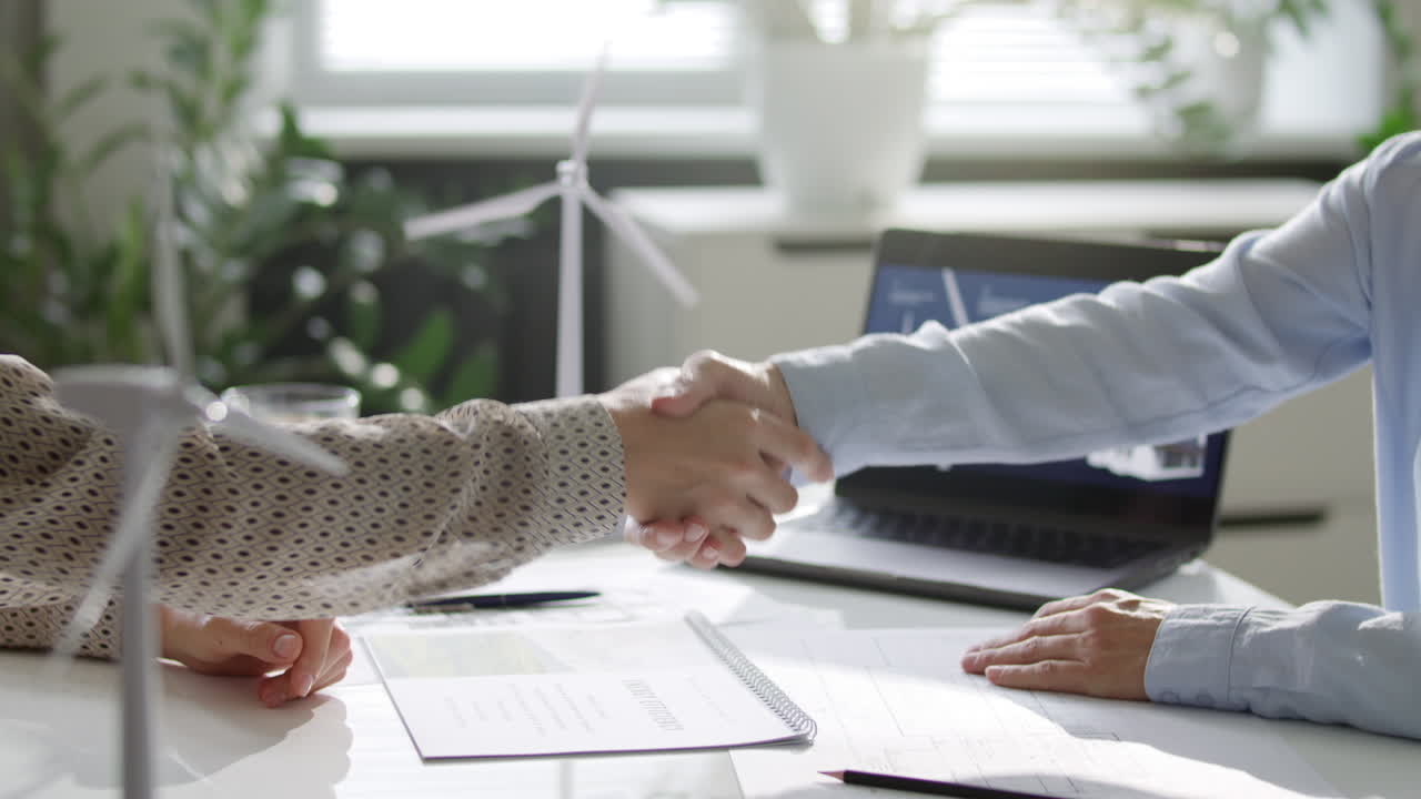 Two Green Energy Engineers Finalizing Office Meeting with Handshake