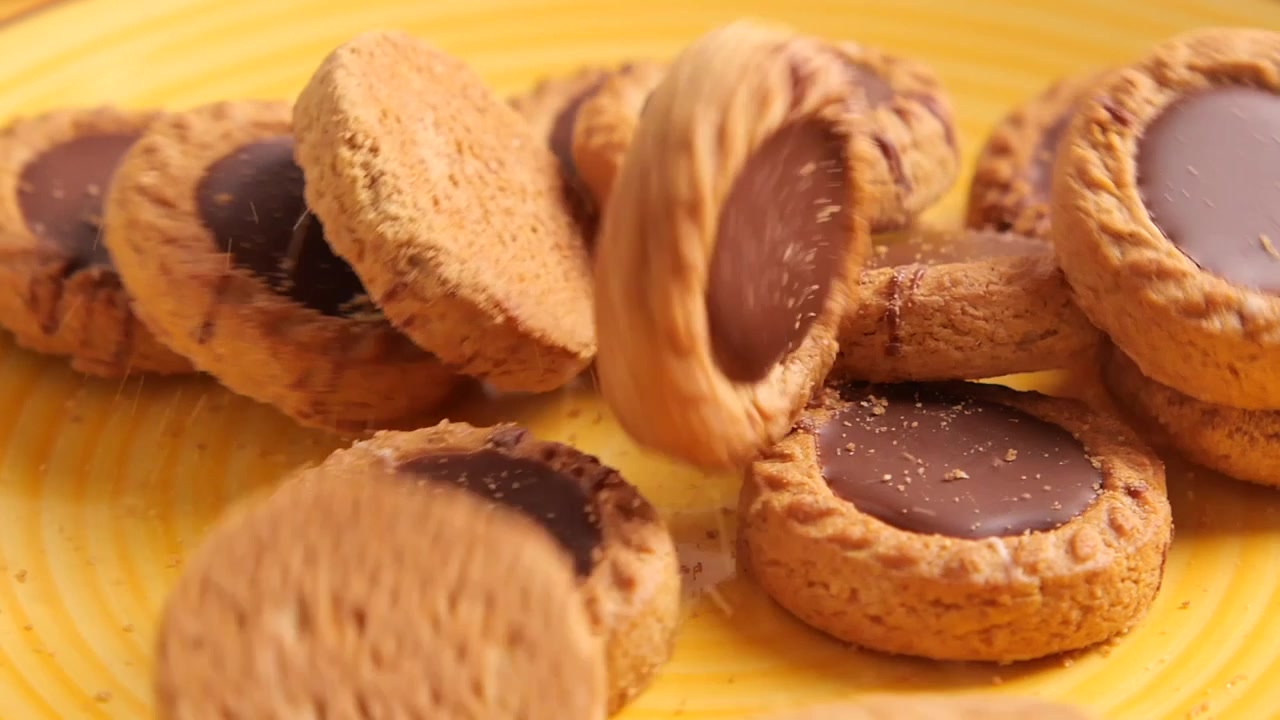 Biscotti ripieni di cioccolato che cadono su un piatto giallo