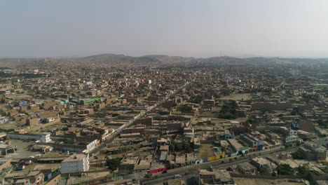 Drone-shot-rising-overview-of-the-cityscape-of-Huacho-city,-sunny-day-in-Peru