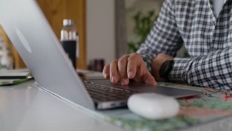 persona que trabaja en una computadora portátil en casa