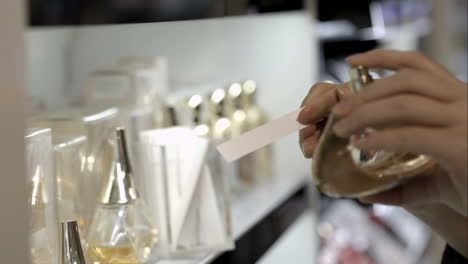 woman in the shop choosing perfume with paper tester