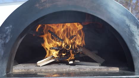 wood burning in smokey wood fire pizza oven outdoors