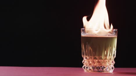 Video-Von-Angezündetem-Alkohol-Im-Glas-Mit-Gelben-Feuerflammen-Und-Kopierraum-Auf-Schwarzem-Hintergrund