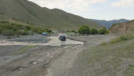 Fahrzeug-Fährt-über-Die-Flussberge-In-Der-Nähe-Des-Dorfes-Saty-In-Kasachstan,-Zentralasien