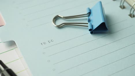 to do list in a notebook with a blue binder clip