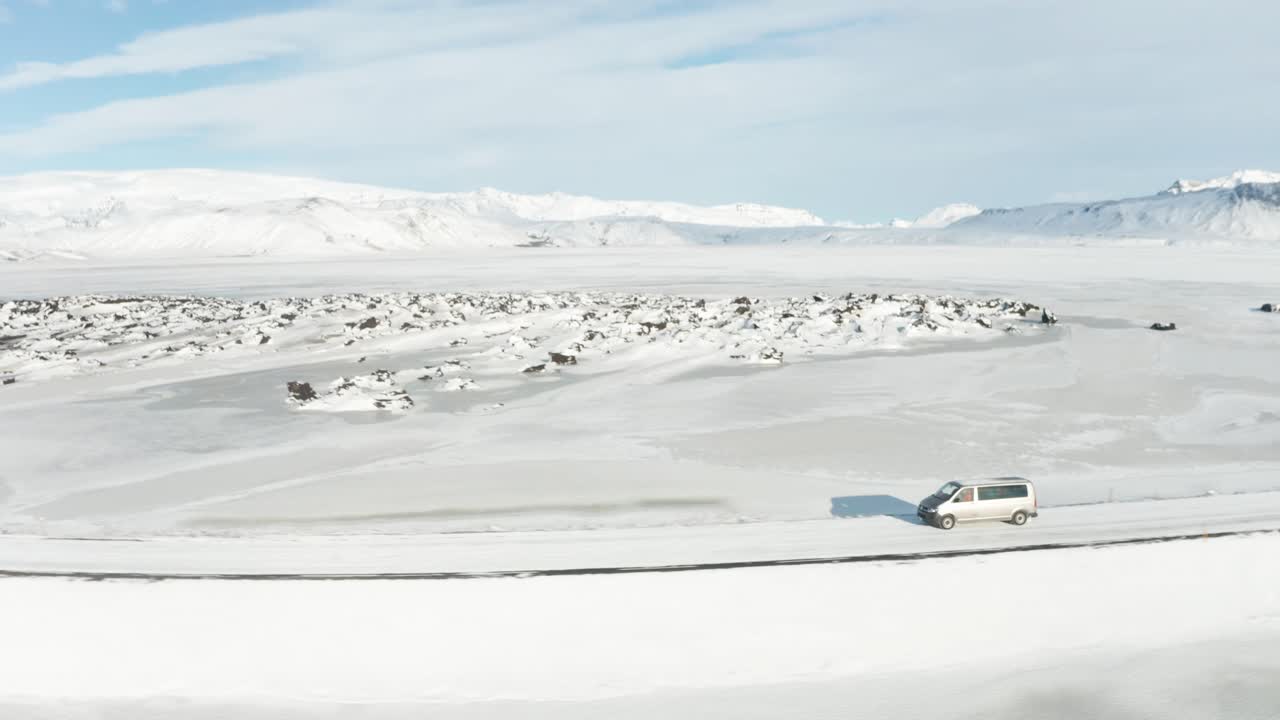 눈 한가운데를 달리는 회색 자동차의 추적 샷