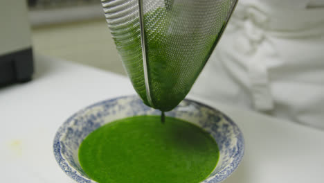 straining spinach leaves for juice puree extraction