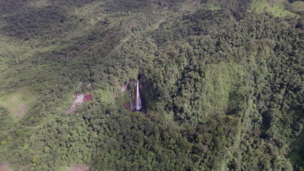 An awe-inspiring aerial perspective of the magnificent Catarata del Toro waterfall, showcasing its powerful cascade plunging into a vibrant, extinct volcanic crater