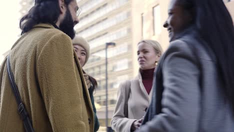 ángulo bajo de un grupo de unidad de personas de negocios en círculo. felices compañeros de trabajo sonrientes. comunidad de diversas edades y trabajo en equipo multirracial. trabajo en equipo alegre en ropa de invierno