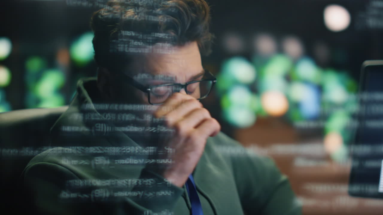 codificador cansado trabajando en una computadora en un holograma de datos de primer plano. hombre frotando los ojos por la noche