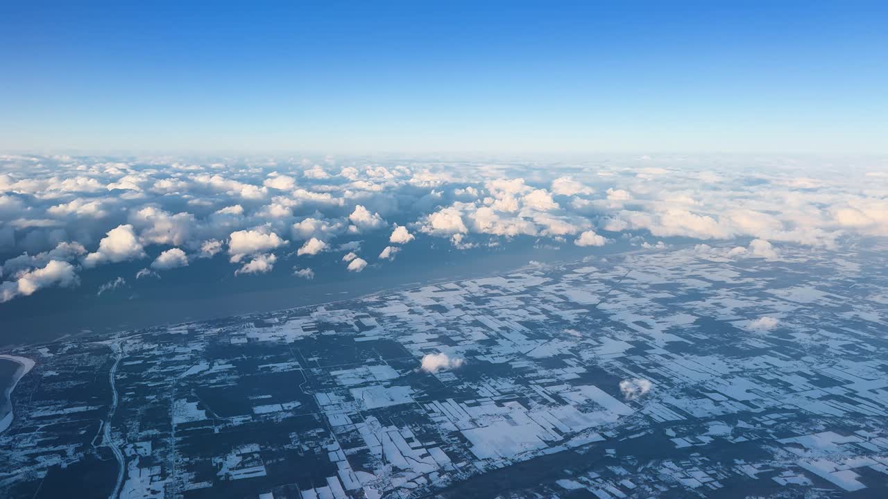 飛行機から見た、雲とスカイラインが広がるオンタリオの雪景色。
