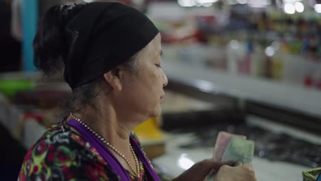 elderly woman selling goods in a market