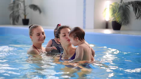 Grupo-De-Mamás-Con-Sus-Bebés-En-La-Clase-De-Natación-Infantil.