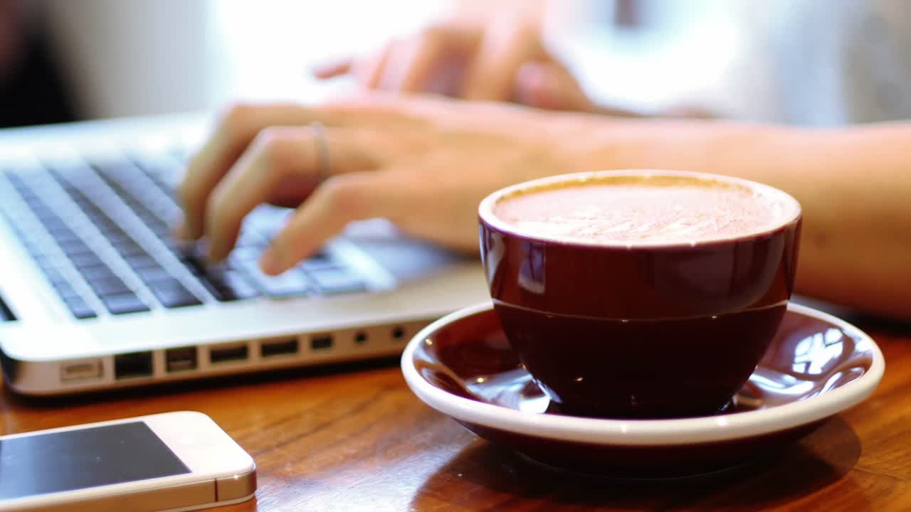 테이블 위에 커피 컵을 가진 노트북을 사용하는 사업가
