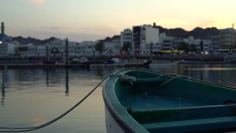 Un-Barco-Estacionado-Atado-A-Un-Muelle-Con-La-Ciudad-Al-Fondo