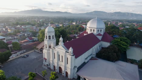 un paisaje majestuoso y resplandeciente vista de drones de una iglesia basílica de la ciudad que tiene río y montañas, batangas, filipinas