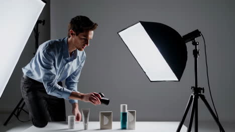 man photographing beauty products in a studio