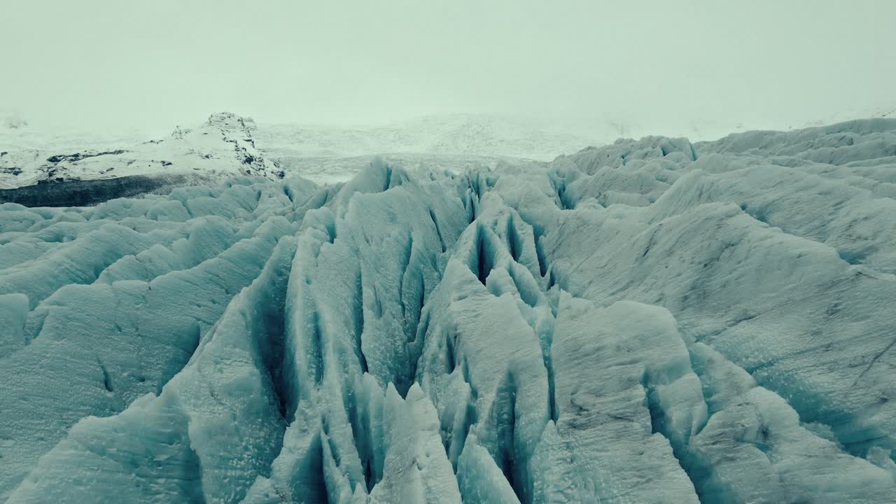 Vista aerea di un vasto ghiacciaio con profondi crepacci di ghiaccio blu