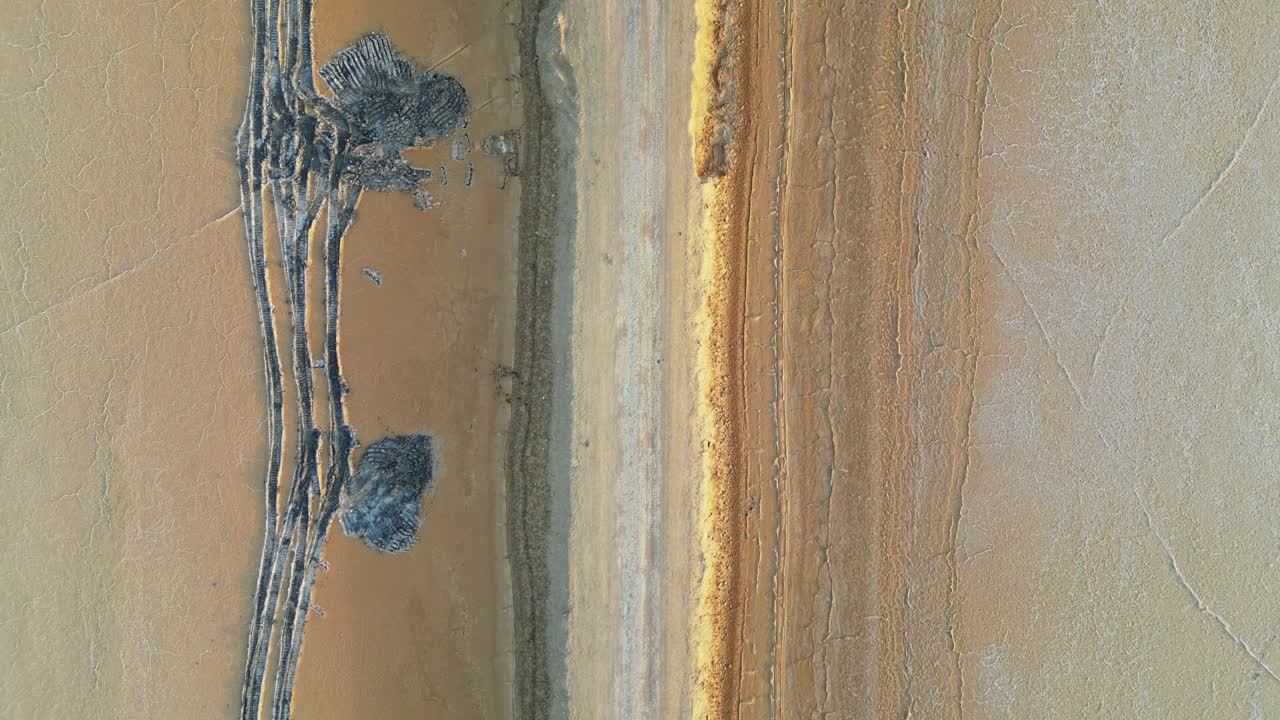 A stunning close-up drone view of the Rann of Kutch, Gujarat, revealing endless stretches of shimmering white and golden sand, capturing the raw, surreal beauty of the salt desert.