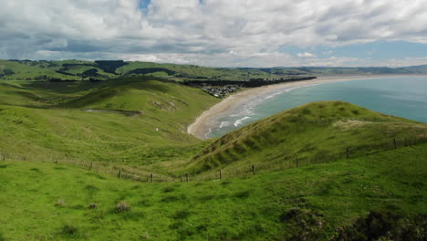 montañas verdes y exuberantes en la playa del municipio de porangahau contra el cielo nublado en la isla norte, nueva zelanda