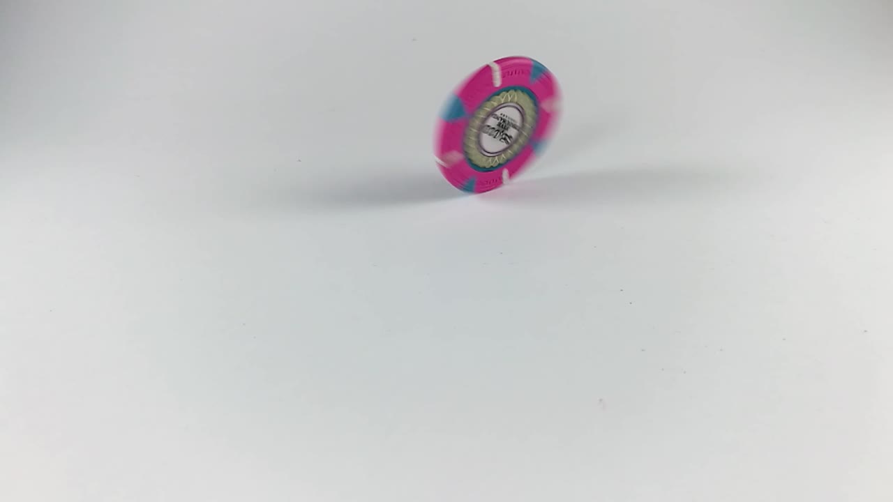 ficha de póquer rosa girando sobre una mesa blanca, aislada, todavía